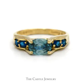 Oval Blue Zircon Ring with Blue Topaz Sides in 14k Yellow Gold Bridge Designed Mounting